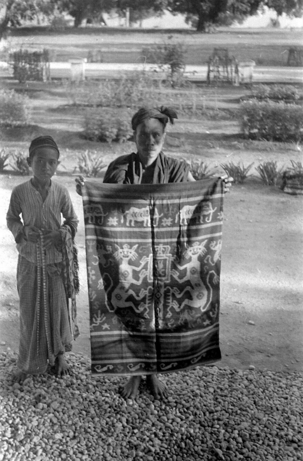 Two men holding an open hinggi for display
