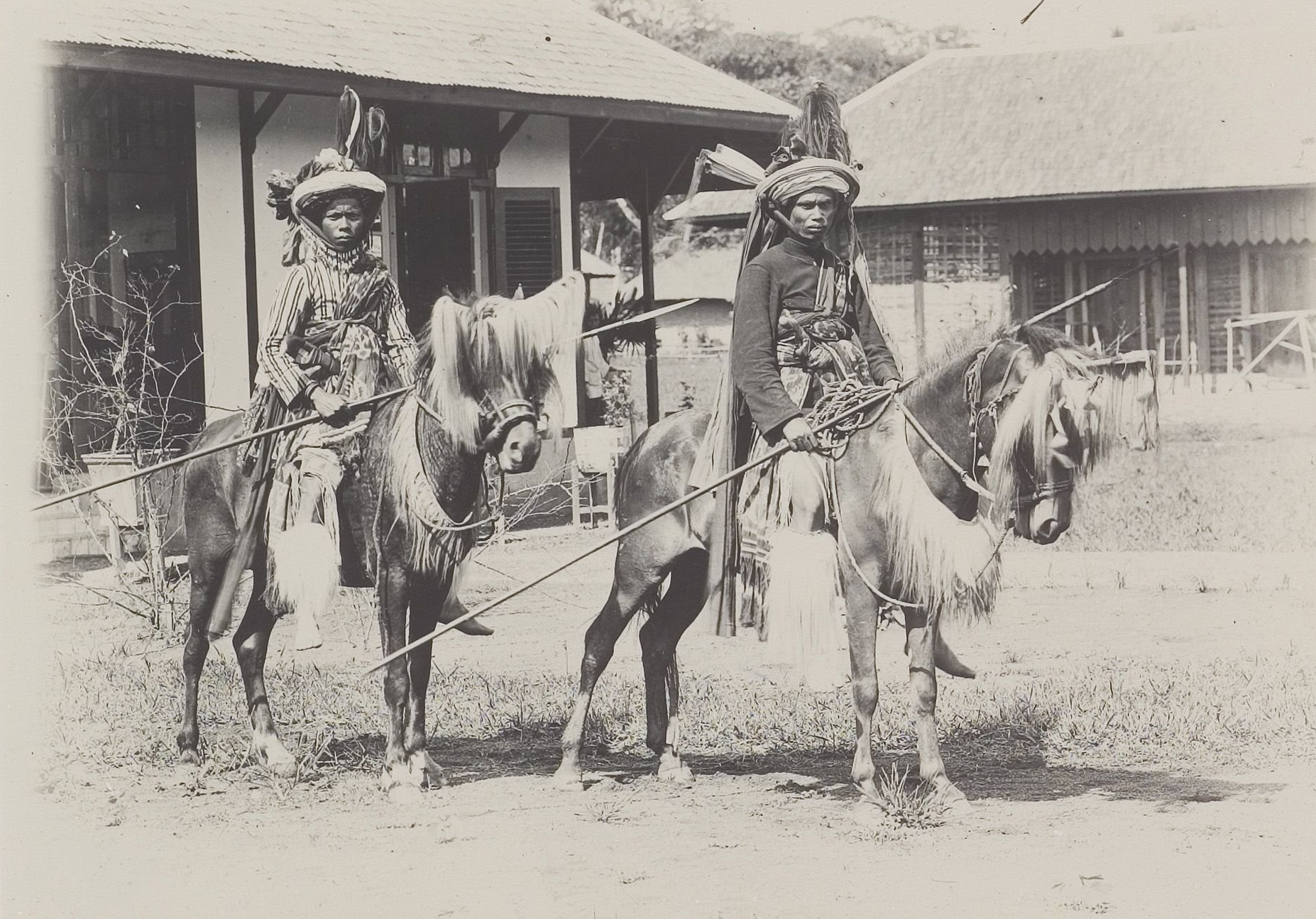 Two riders in decorated head-wraps carrying spears