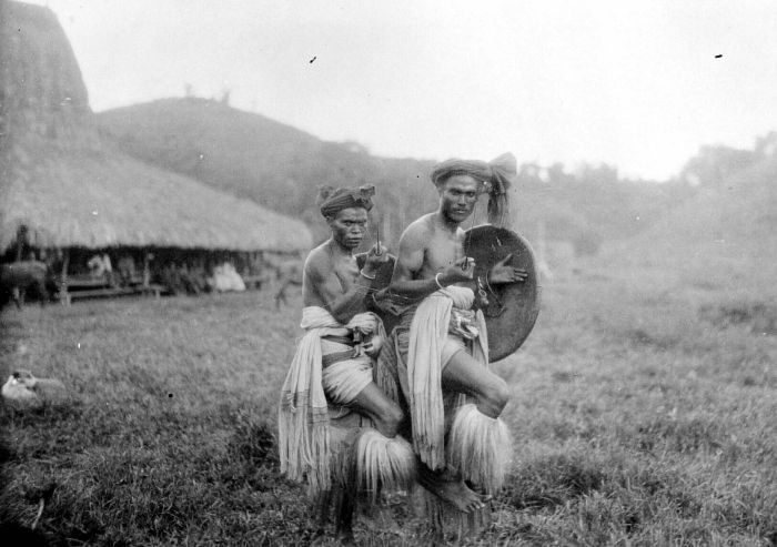 Two men performing the Zaiwo dance with sword and shield