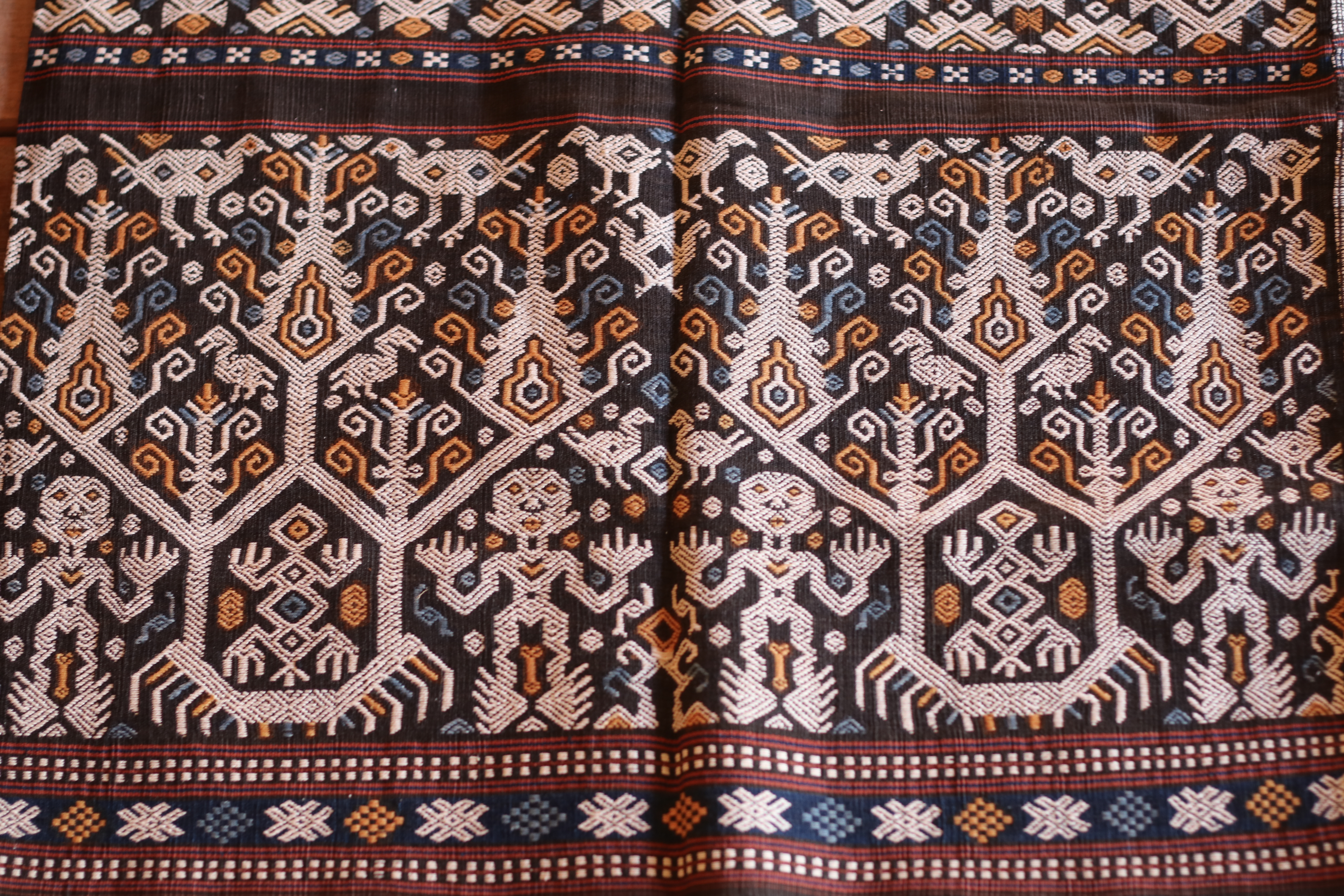 Hinggi with tau human-figure motif band, woven in wora (indigo) and kombu (morinda red), Kambera region