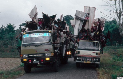 Procession with cloth banners on trucks