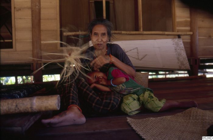 Woman preparing fibre with child