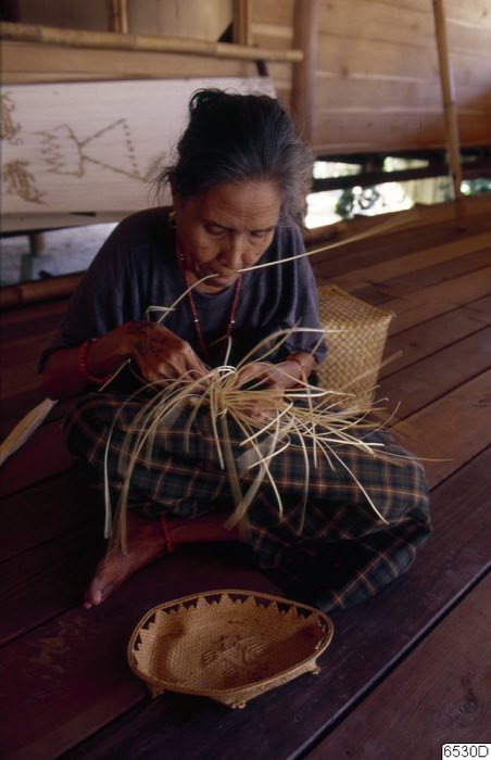Woman plaiting inside a stilt house