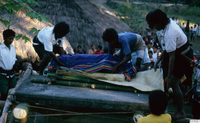 Textile-wrapped corpse on a bier, Laboya