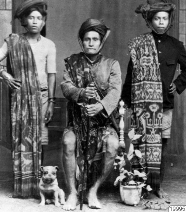 Studio portrait of three East Sumbanese men wearing hinggi ikat, colonial era